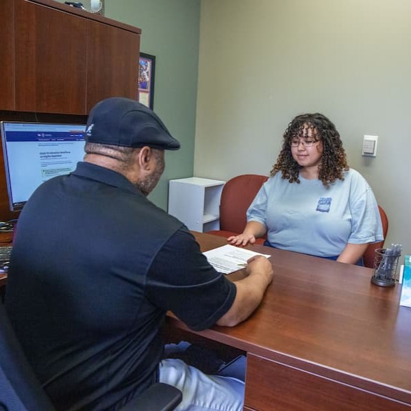 An MCC staff member assists a student at the Financial Aid office.
