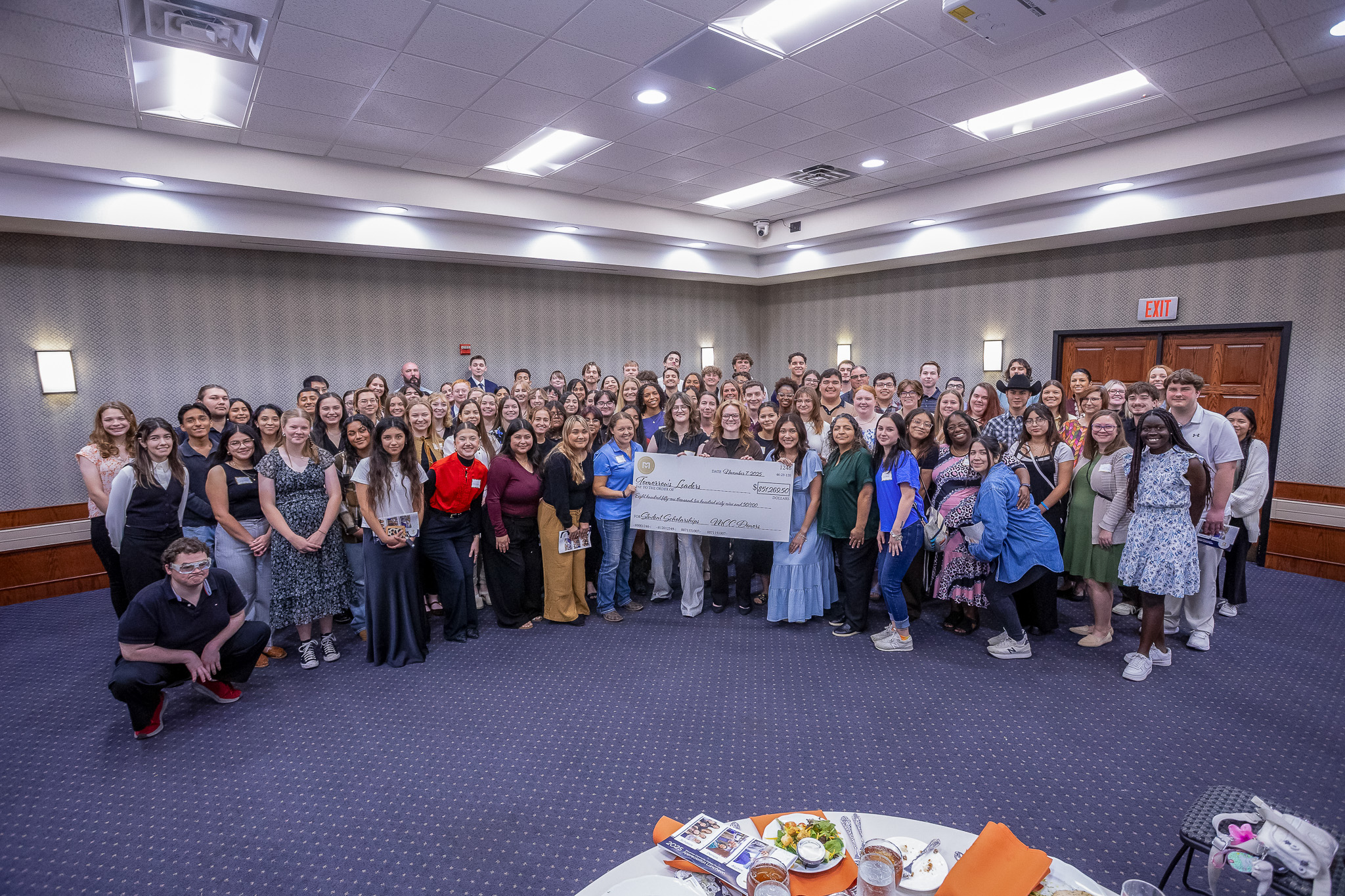 students surrounding paper check of award amount