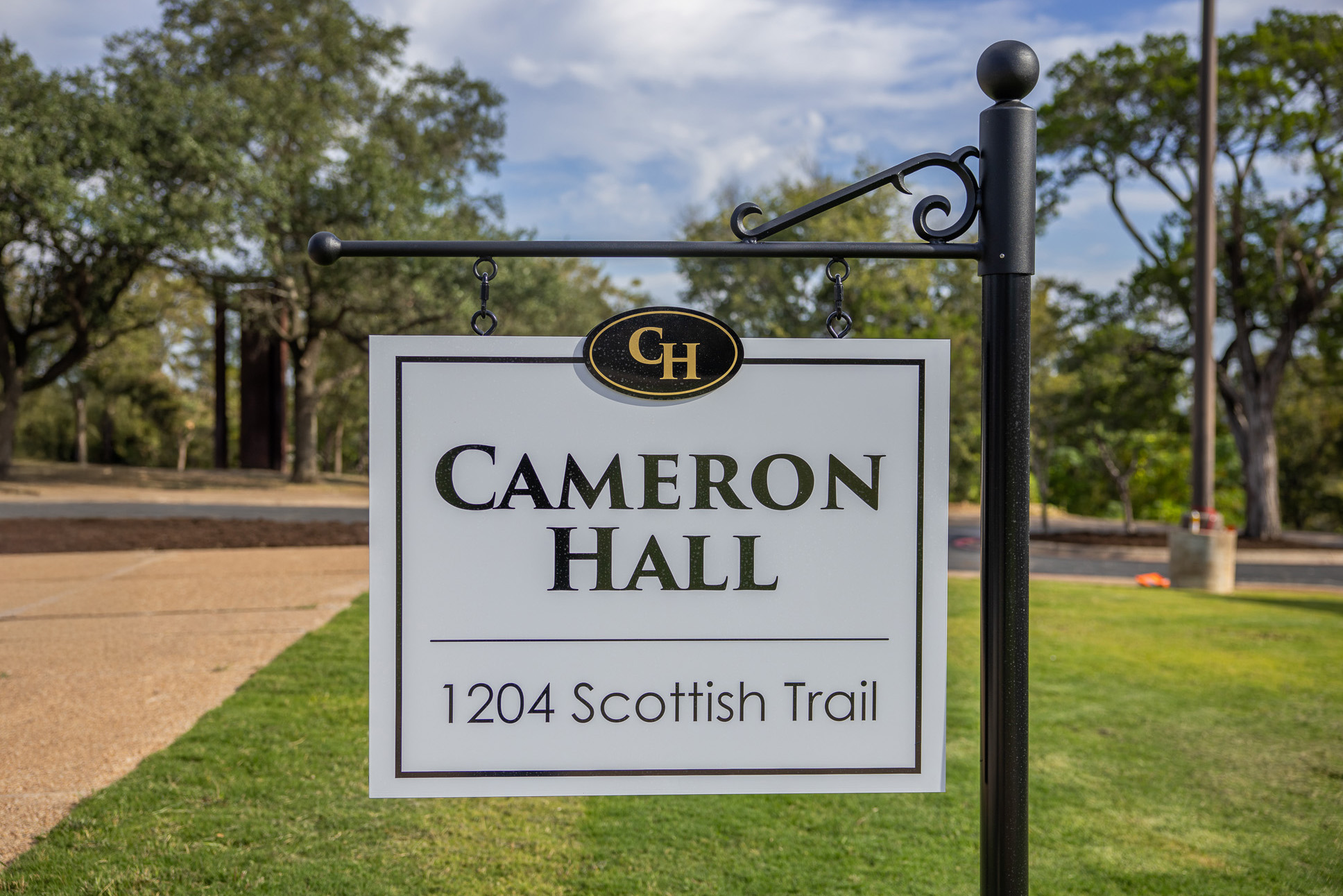 Sign for Cameron Hall located at 1204 Scottish Trail, featuring a classic design and green surroundings.